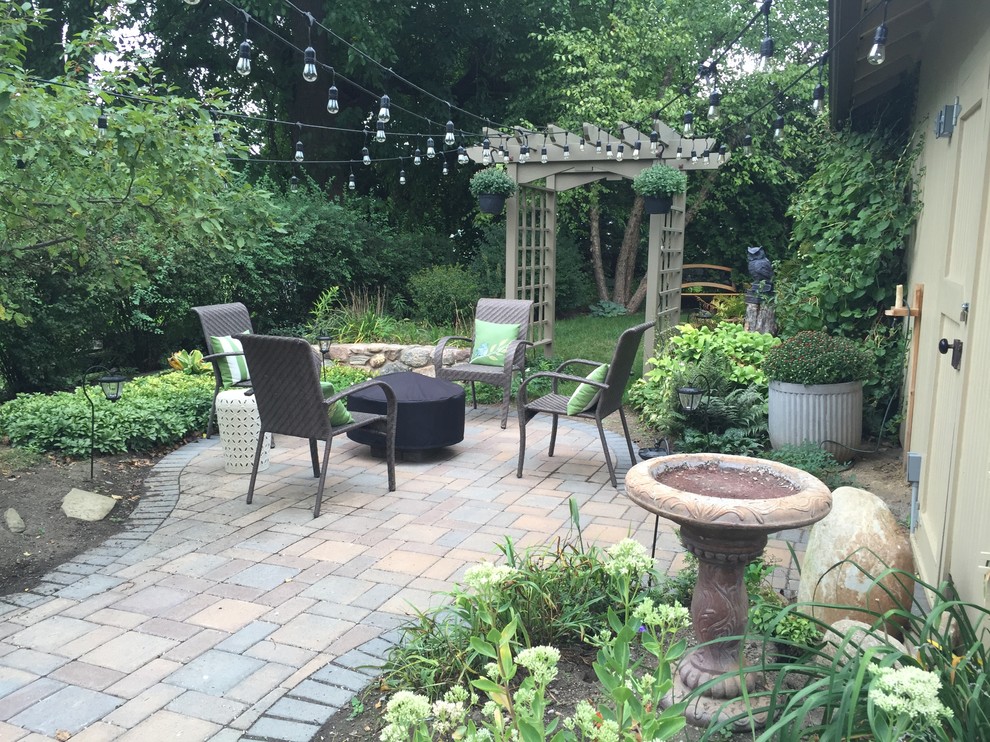 Photo of a large traditional backyard patio in Detroit with a fire feature, concrete pavers and no cover.