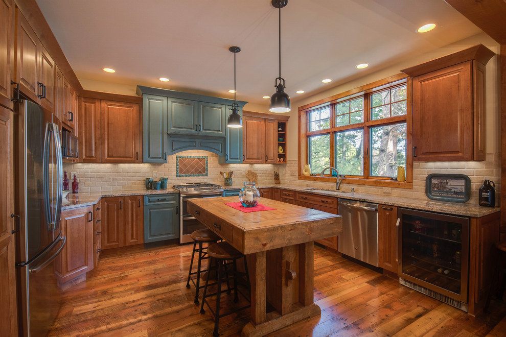 Photo of a country u-shaped kitchen in Other with an undermount sink, raised-panel cabinets, medium wood cabinets, beige splashback, stainless steel appliances, dark hardwood floors, with island and brown floor.