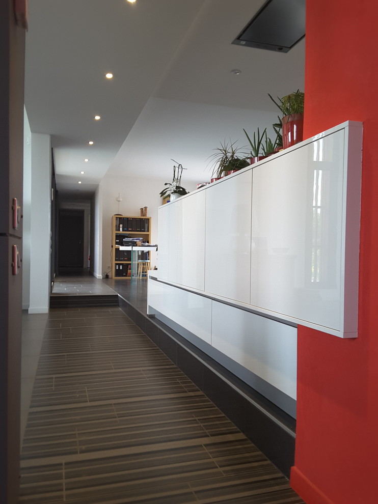 Large contemporary hallway in Paris with white walls, ceramic floors and grey floor.