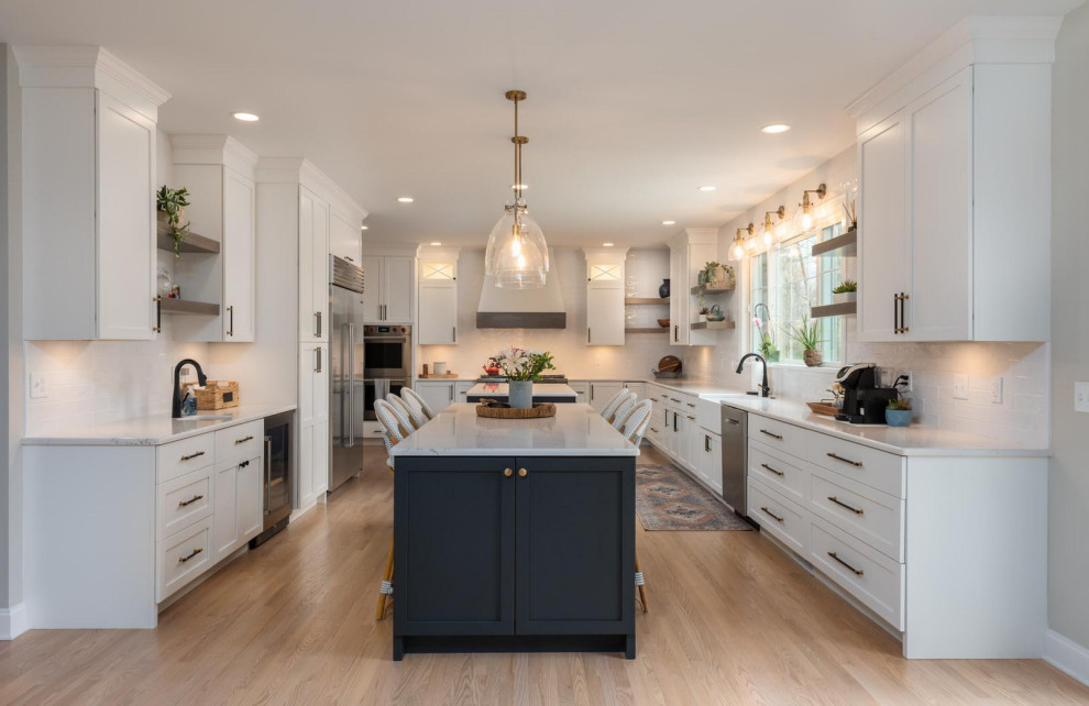 Eat-in kitchen - huge transitional galley light wood floor and gray floor eat-in kitchen idea with a farmhouse sink, recessed-panel cabinets, white cabinets, quartz countertops, white backsplash, subway tile backsplash, stainless steel appliances, two islands and white countertops