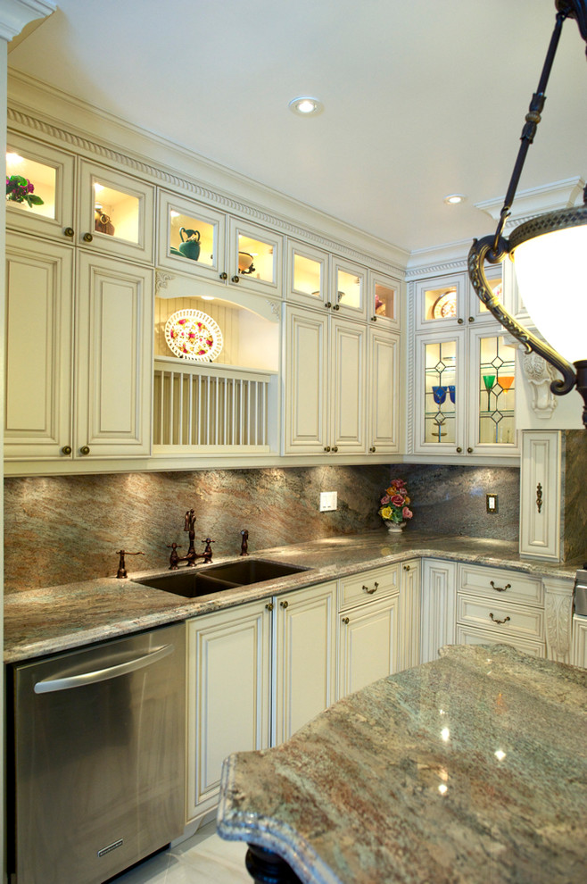 This is an example of a large traditional u-shaped eat-in kitchen in Toronto with an undermount sink, raised-panel cabinets, white cabinets and granite benchtops.