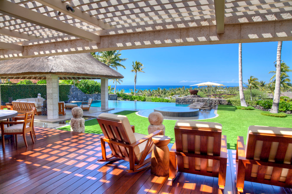 Photo of a tropical backyard deck in Hawaii with a pergola.