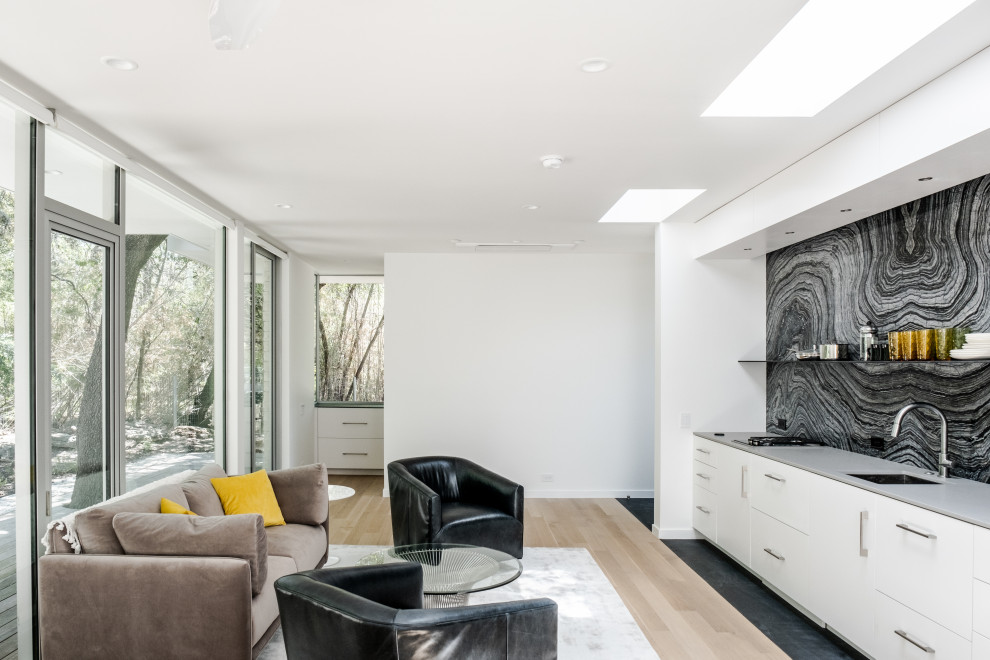 Mid-sized midcentury open concept living room in Austin with medium hardwood floors and beige floor.
