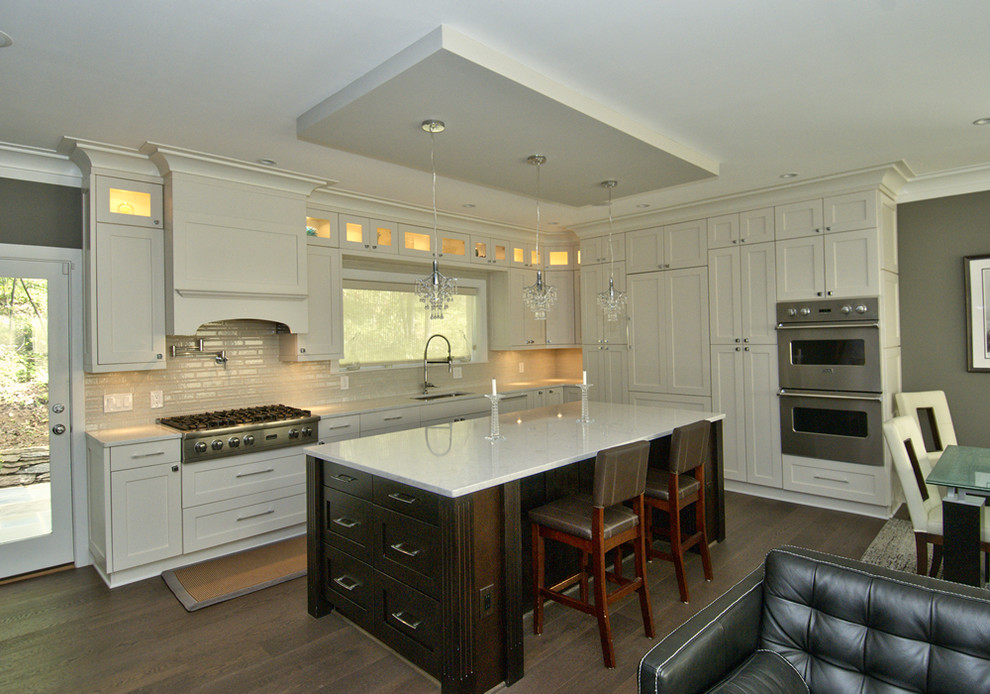 Inspiration for a mid-sized transitional l-shaped dark wood floor open concept kitchen remodel in DC Metro with an undermount sink, shaker cabinets, white cabinets, quartz countertops, beige backsplash, porcelain backsplash, stainless steel appliances and an island