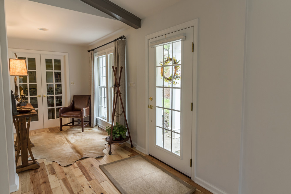 Entry hall - mid-sized transitional medium tone wood floor entry hall idea with white walls and a glass front door