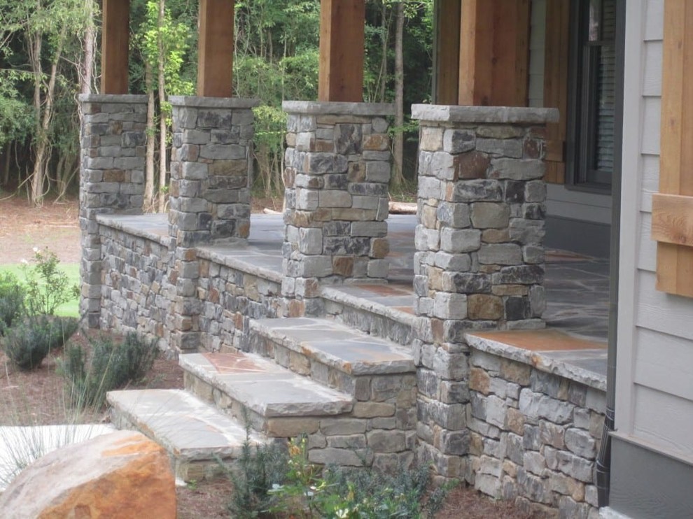 Mid-sized country front yard verandah in Other with natural stone pavers and a roof extension.
