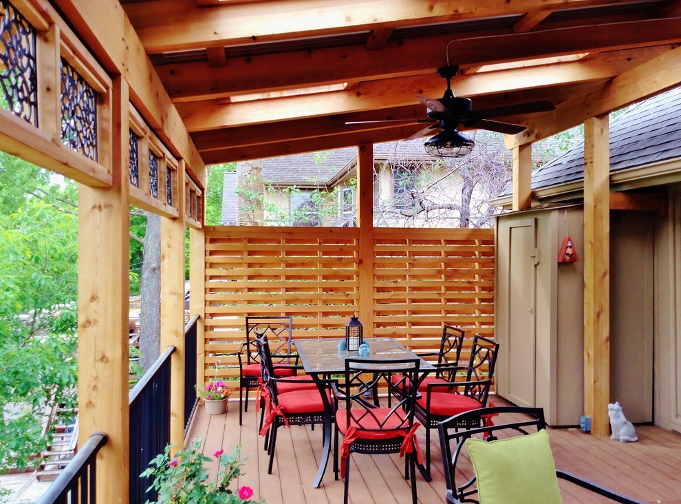 This is an example of a mid-sized country backyard deck in Kansas City with a pergola.