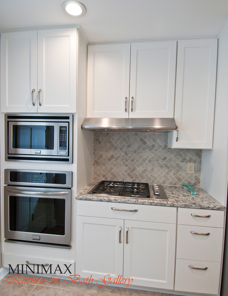 Mid-sized transitional u-shaped porcelain tile eat-in kitchen photo with an undermount sink, shaker cabinets, white cabinets, quartz countertops, gray backsplash, stone tile backsplash and stainless steel appliances