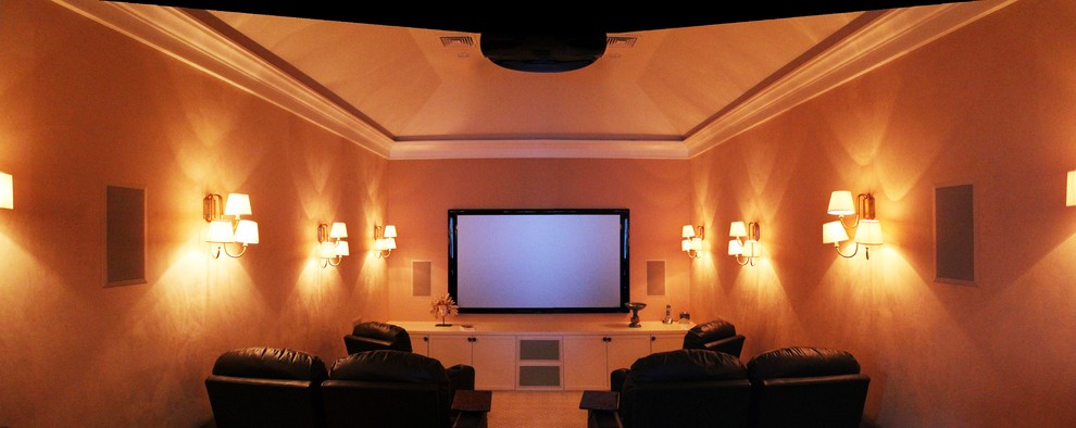 Photo of a mid-sized mediterranean enclosed home theatre in Boston with beige walls, light hardwood floors and a projector screen.