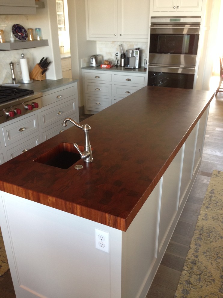 This is an example of a contemporary kitchen in Austin with a drop-in sink and wood benchtops.