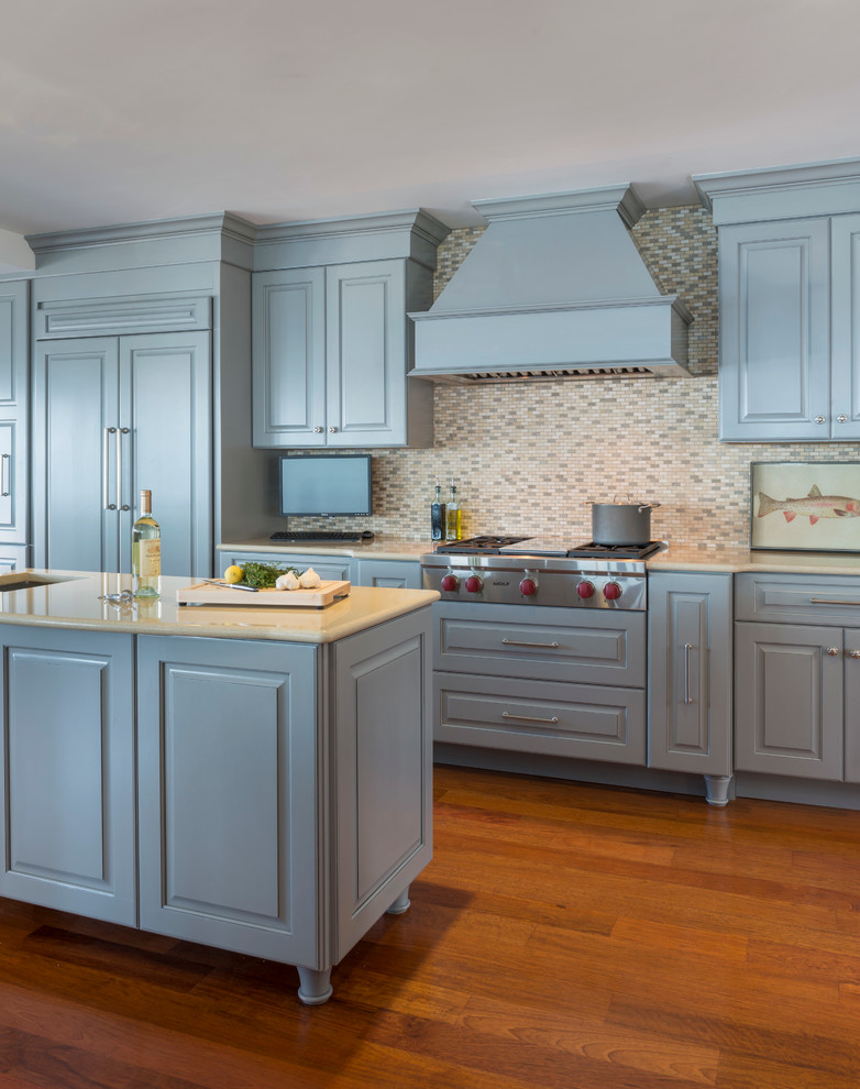 Inspiration for a large traditional u-shaped eat-in kitchen in Providence with a drop-in sink, raised-panel cabinets, blue cabinets, granite benchtops, multi-coloured splashback, matchstick tile splashback, stainless steel appliances, medium hardwood floors and multiple islands.