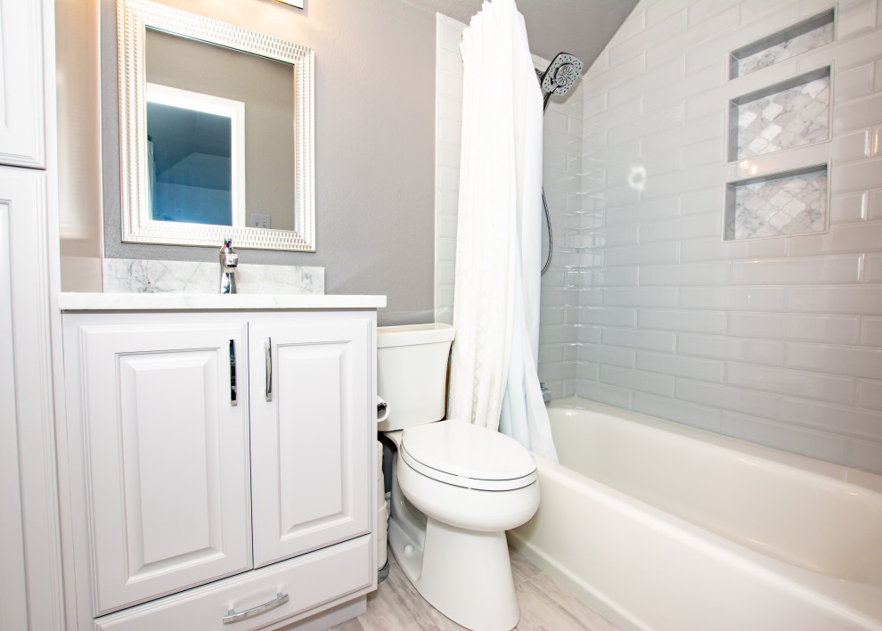 Inspiration for a transitional master gray tile and subway tile porcelain tile and double-sink freestanding bathtub remodel in Austin with raised-panel cabinets, gray cabinets, a two-piece toilet, gray walls, an undermount sink, granite countertops, a hinged shower door, a niche and a built-in vanity