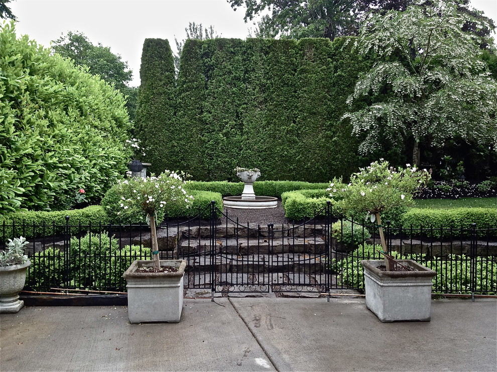 Large traditional backyard formal garden in Portland with a garden path and natural stone pavers.