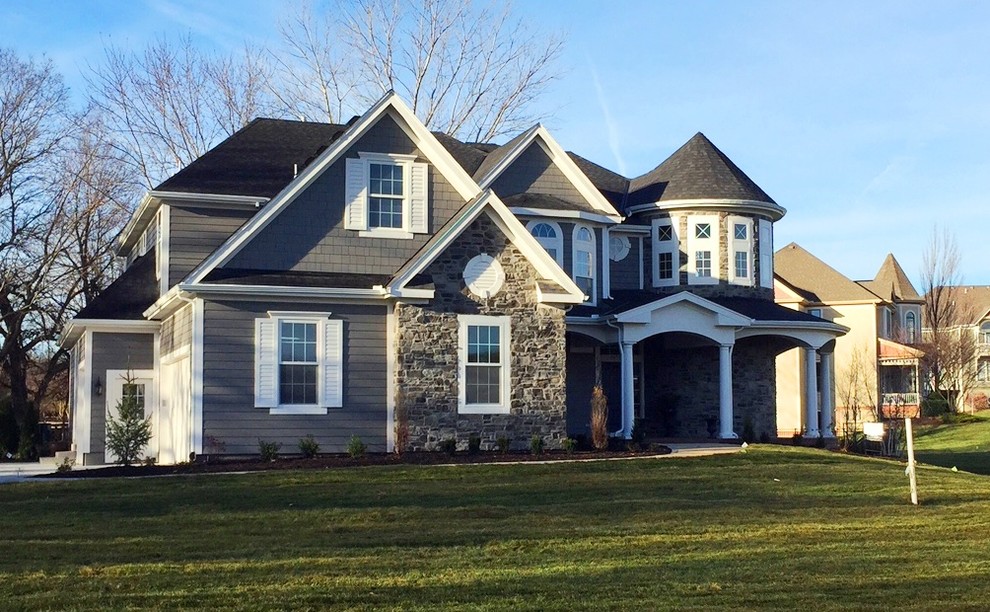 Photo of a large traditional two-storey grey exterior in Kansas City with mixed siding.
