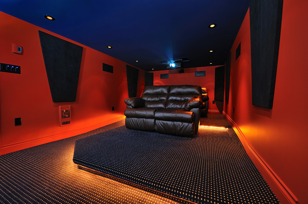Small modern enclosed home theatre in Vancouver with red walls, carpet and a projector screen.