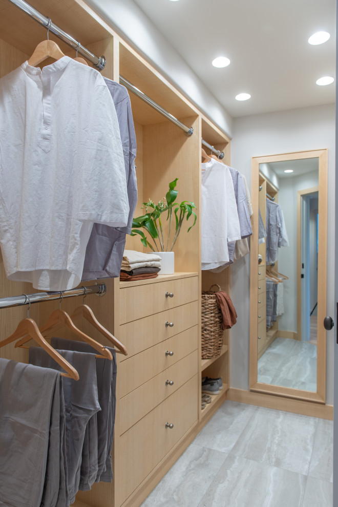 Photo of a large scandinavian walk-in wardrobe in Los Angeles with flat-panel cabinets, light wood cabinets, porcelain floors and grey floor.