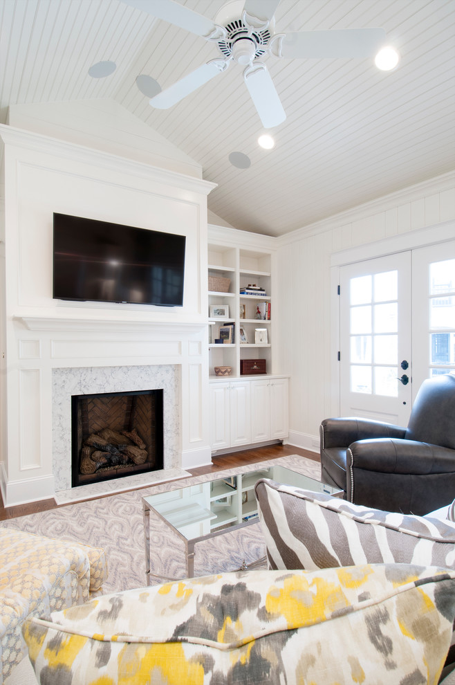 This is an example of a transitional open concept family room in Raleigh with white walls, dark hardwood floors, a standard fireplace, a stone fireplace surround and a wall-mounted tv.