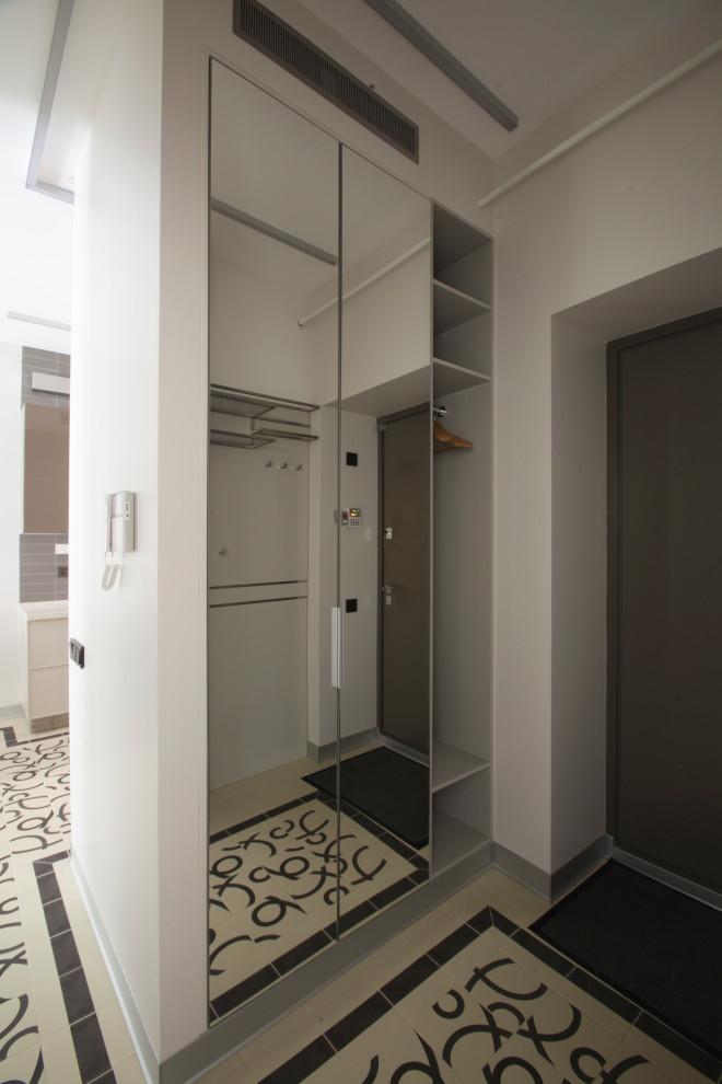 Modern inredning av en liten ingång och ytterdörr, med en enkeldörr och en grå dörr