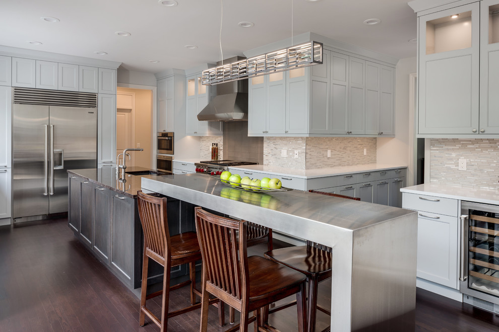 Example of a transitional dark wood floor and brown floor kitchen design in Detroit with an undermount sink, shaker cabinets, dark wood cabinets, gray backsplash, matchstick tile backsplash, stainless steel appliances, an island and white countertops