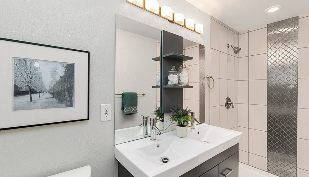 Alcove shower - small transitional master gray tile and porcelain tile ceramic tile alcove shower idea in Seattle with flat-panel cabinets, gray cabinets, a one-piece toilet, gray walls, an integrated sink and solid surface countertops