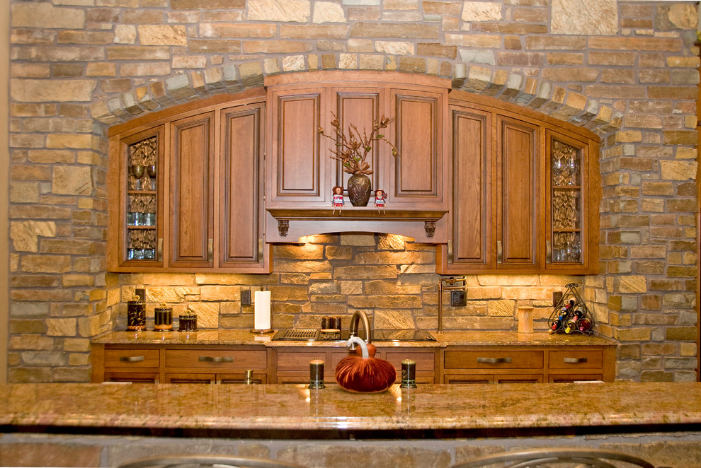 Open concept kitchen - large transitional l-shaped open concept kitchen idea in Cedar Rapids with a farmhouse sink, raised-panel cabinets, medium tone wood cabinets, granite countertops, stainless steel appliances and an island