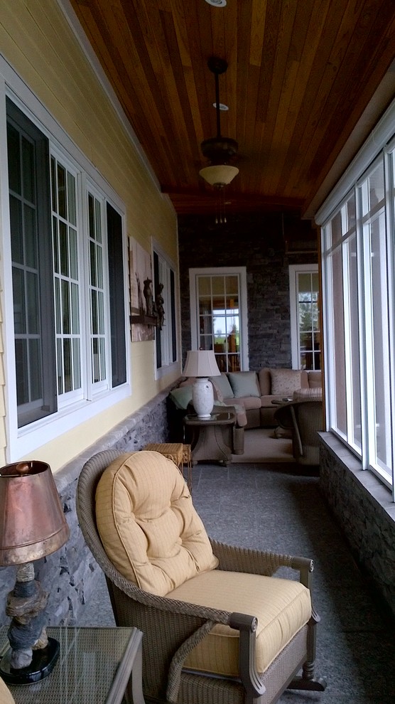 Example of a large transitional backyard stone screened-in home design design in Toronto with a roof extension