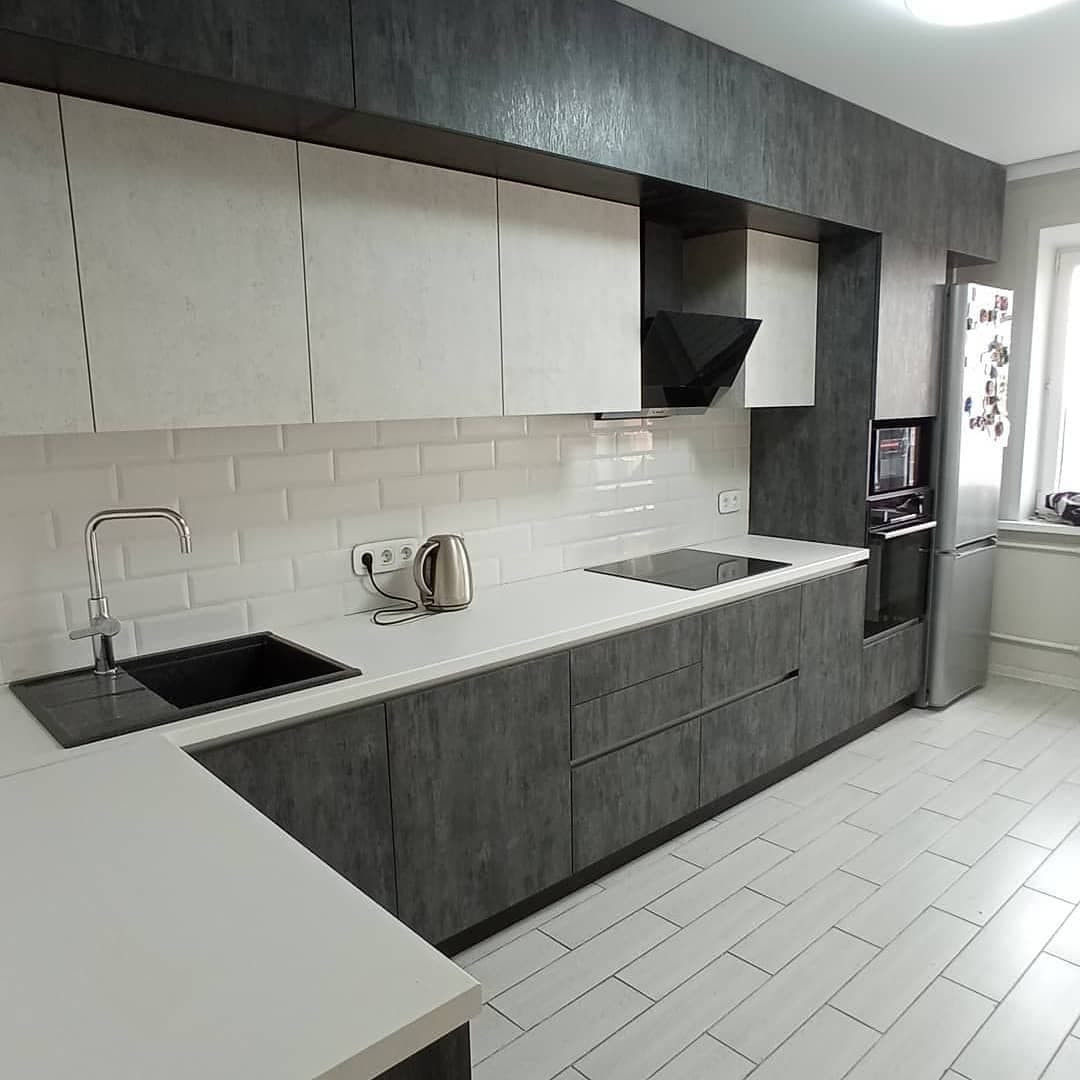 Широкая угловая черно-белая кухня с фасадами под камень