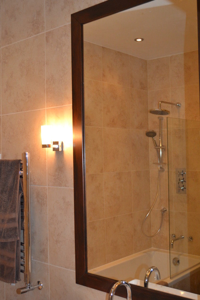 Cette image montre une petite salle d'eau minimaliste en bois foncé avec un placard à porte plane, une baignoire posée, un combiné douche/baignoire, WC à poser, un carrelage beige, des carreaux de céramique, un mur beige, un lavabo suspendu et un sol en carrelage de céramique.