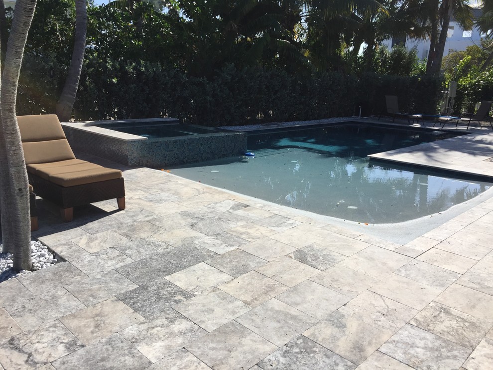 Großer Pool hinter dem Haus mit Natursteinplatten in Miami
