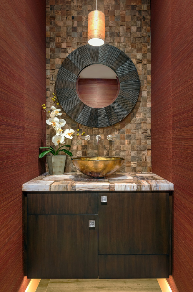 Inspiration for a contemporary powder room in Phoenix with a vessel sink, flat-panel cabinets, dark wood cabinets, brown tile, stone tile, red walls and multi-coloured benchtops.