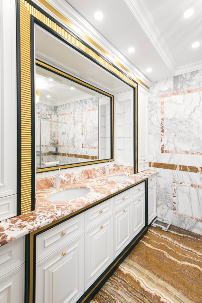 This is an example of a mid-sized transitional master wet room bathroom in Moscow with raised-panel cabinets, white cabinets, a wall-mount toilet, white tile, marble, white walls, marble floors, an integrated sink, marble benchtops, white floor, a hinged shower door, orange benchtops, an enclosed toilet, a double vanity and a built-in vanity.