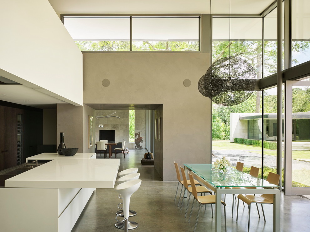 This is an example of a contemporary dining room in Houston with grey walls, concrete floors and grey floor.