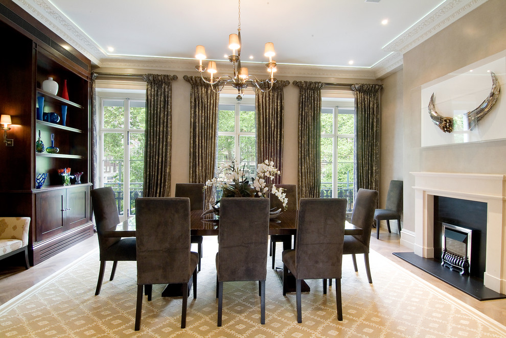 Inspiration for a large contemporary dining room in DC Metro with beige walls, light hardwood floors, a standard fireplace, a stone fireplace surround and brown floor.