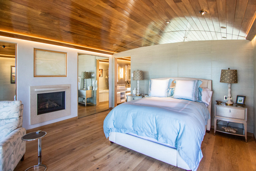 他の地域にあるビーチスタイルのおしゃれな主寝室 (無垢フローリング、標準型暖炉、板張り天井)