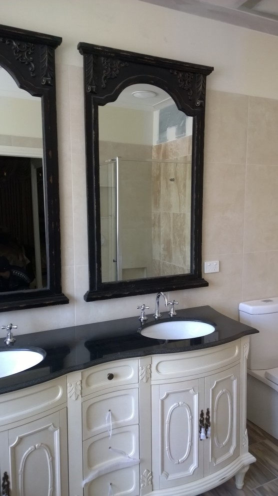 Photo of a mid-sized mediterranean master bathroom in Melbourne with an undermount sink, furniture-like cabinets, beige cabinets, granite benchtops, a corner shower, multi-coloured tile, porcelain tile, multi-coloured walls and porcelain floors.