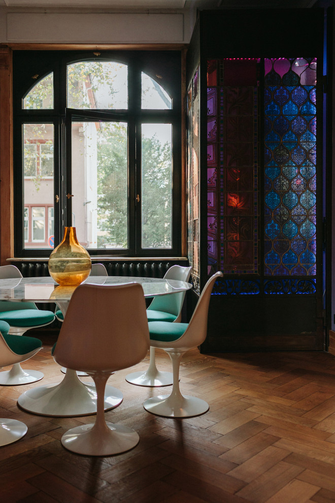 Modelo de comedor actual con paredes púrpuras, suelo de madera en tonos medios y suelo marrón