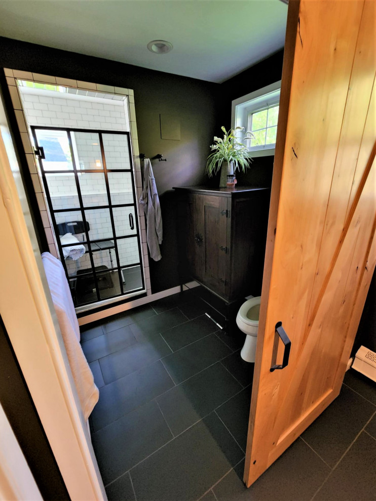 This is an example of a mid-sized transitional master bathroom in Manchester with recessed-panel cabinets, an alcove shower, white tile, ceramic tile, black walls, porcelain floors, an undermount sink, engineered quartz benchtops, black floor, a hinged shower door, white benchtops, a double vanity, a freestanding vanity and dark wood cabinets.