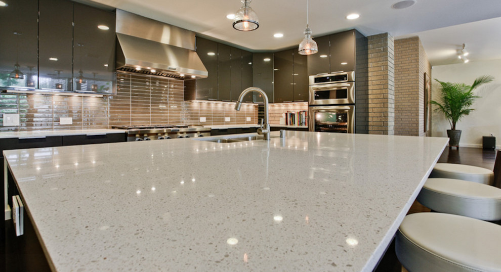 Example of a mid-sized transitional l-shaped open concept kitchen design in Toronto with a double-bowl sink, flat-panel cabinets, brown cabinets, quartz countertops, beige backsplash, glass tile backsplash, stainless steel appliances and an island