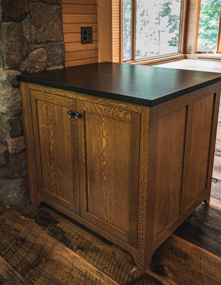 Inspiration for a rustic medium tone wood floor and exposed beam kitchen remodel with an undermount sink, shaker cabinets, granite countertops, black backsplash, granite backsplash, stainless steel appliances, an island and black countertops