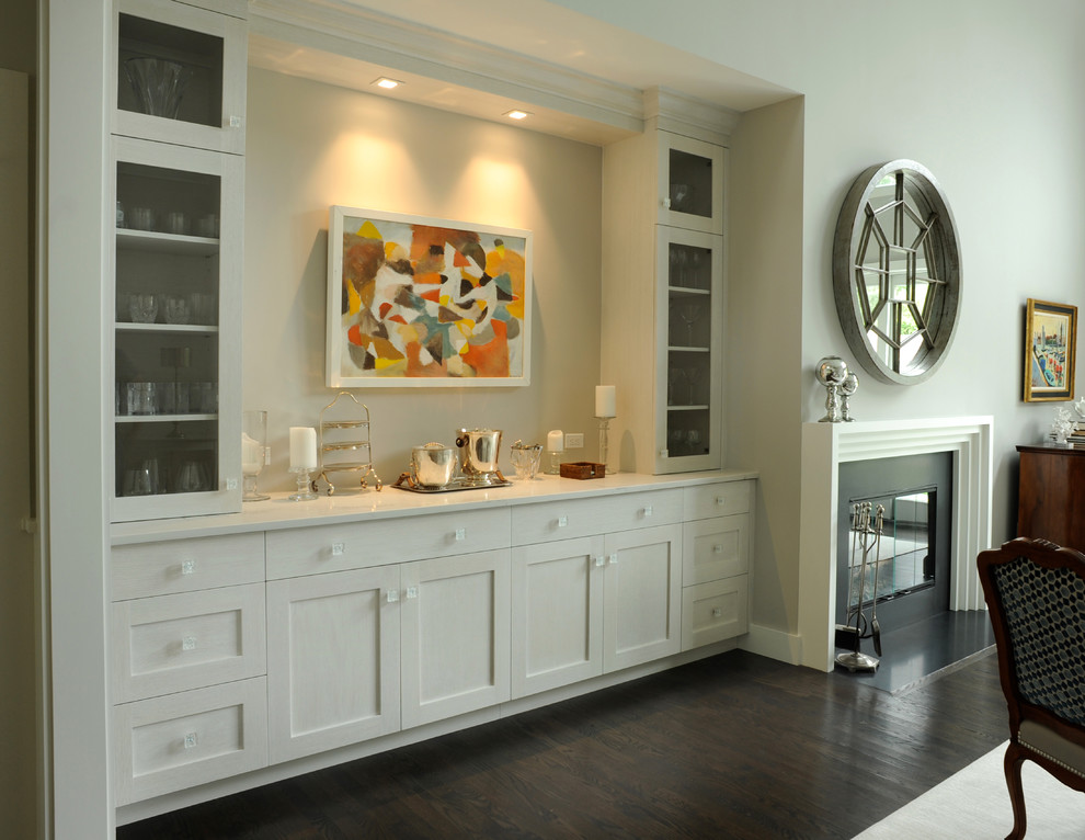 Design ideas for a mid-sized transitional single-wall wet bar in New York with no sink, shaker cabinets, white cabinets, solid surface benchtops, dark hardwood floors and brown floor.