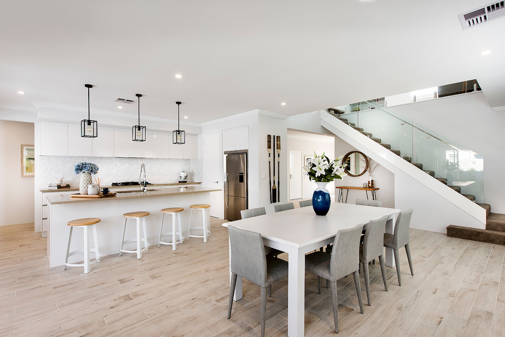 Inspiration for a beach style kitchen/dining combo in Perth with white walls and ceramic floors.