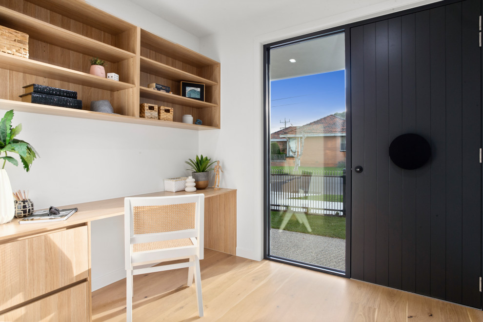 Moderner Eingang mit weißer Wandfarbe, hellem Holzboden, Einzeltür, schwarzer Haustür und beigem Boden in Melbourne