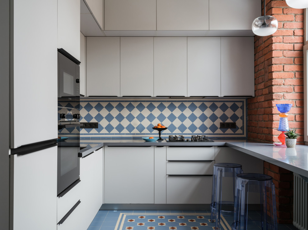 Inredning av ett modernt avskilt, mellanstort grå grått u-kök, med en undermonterad diskho, släta luckor, grå skåp, bänkskiva i koppar, grått stänkskydd, svarta vitvaror, cementgolv, en köksö och blått golv