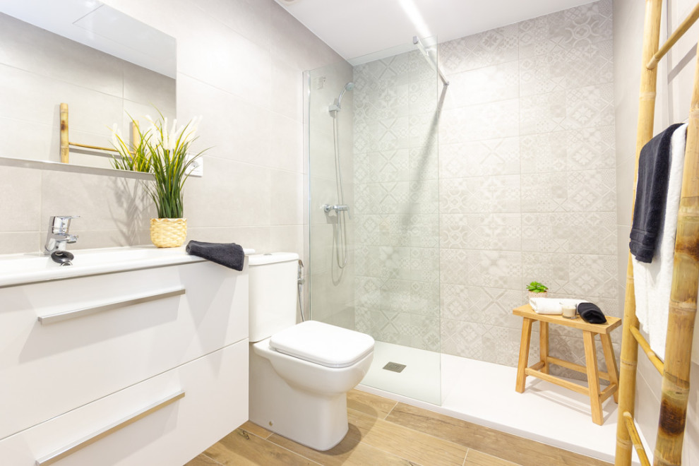 Inspiration för små skandinaviska vitt en-suite badrum, med vita skåp, våtrum, en toalettstol med hel cisternkåpa, grå kakel, keramikplattor, grå väggar och brunt golv
