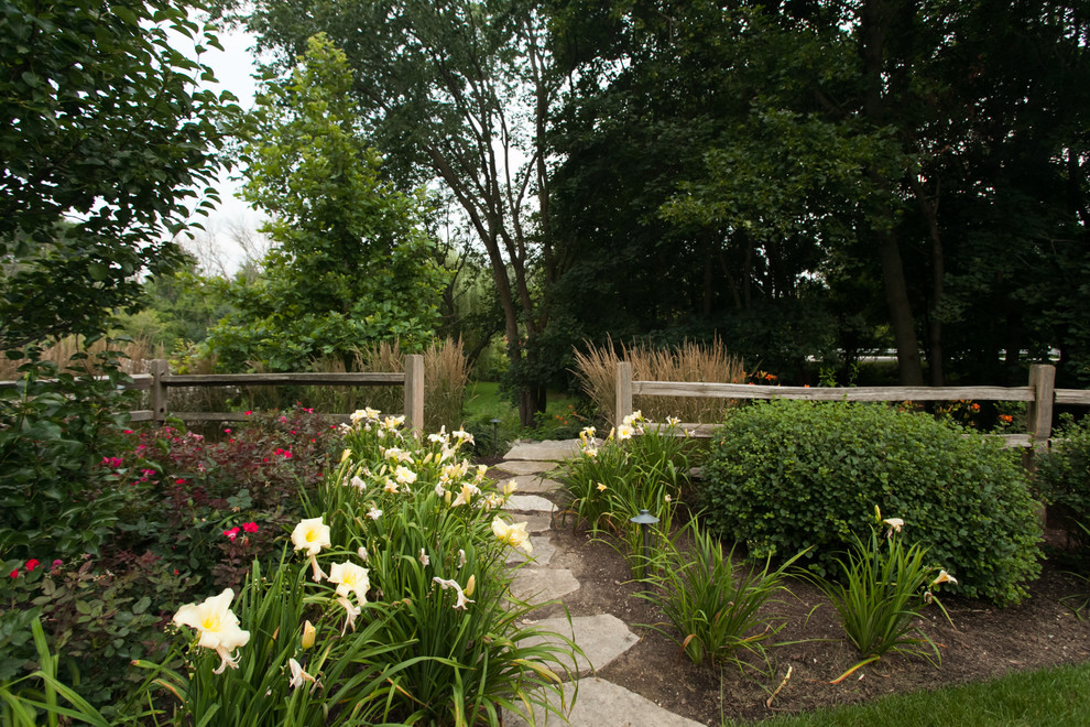 Inspiration for a mid-sized country side yard full sun garden for summer in Chicago with natural stone pavers.