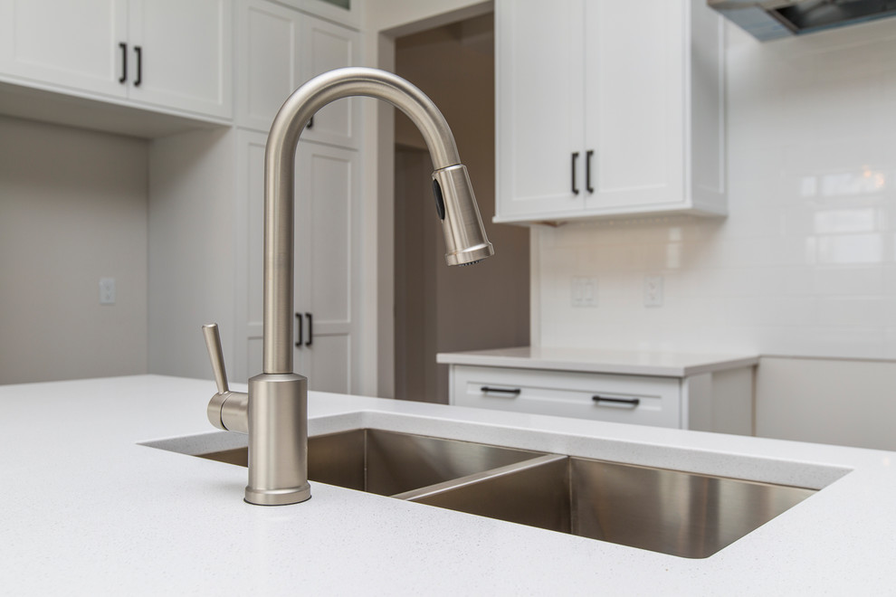 Open concept kitchen - large transitional l-shaped medium tone wood floor open concept kitchen idea in Ottawa with an undermount sink, shaker cabinets, white cabinets, quartzite countertops, white backsplash, subway tile backsplash and an island