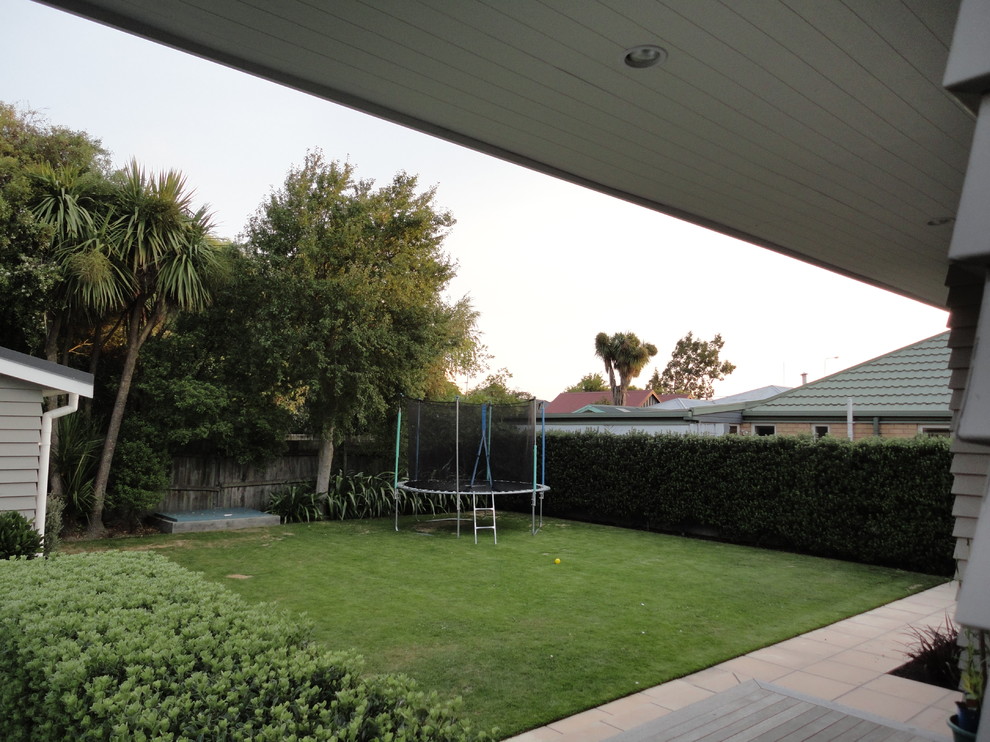 Photo of a country backyard formal garden in Christchurch with with outdoor playset.