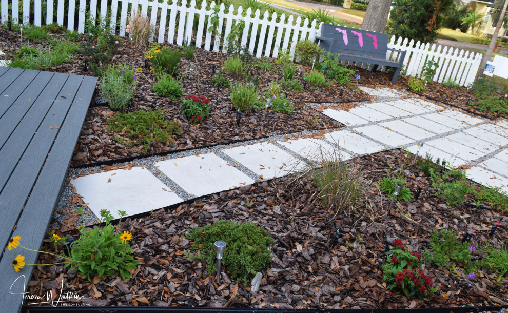 Idee per un piccolo giardino xeriscape design esposto in pieno sole davanti casa in primavera con un ingresso o sentiero, pacciame e recinzione in legno