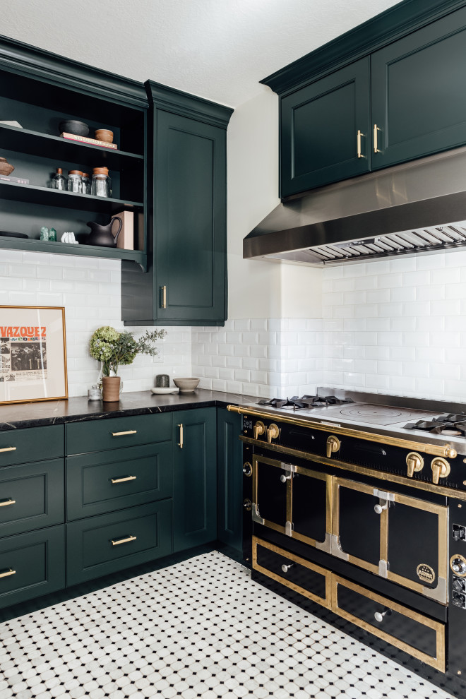 Mid-sized eclectic u-shaped separate kitchen in Salt Lake City with a farmhouse sink, shaker cabinets, blue cabinets, solid surface benchtops, white splashback, ceramic splashback, black appliances, ceramic floors, no island and grey benchtop.
