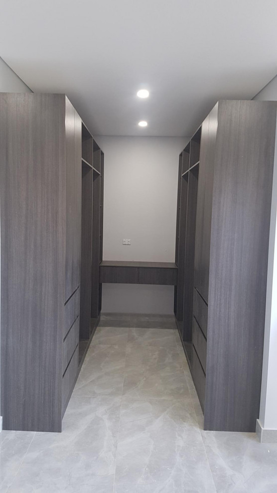 Inspiration for a large contemporary gender-neutral storage and wardrobe in Sydney with dark wood cabinets, ceramic floors and grey floor.